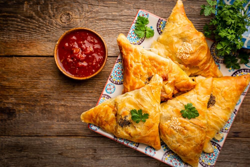 Эчпочмаки, которые подали на тарелке с соусом